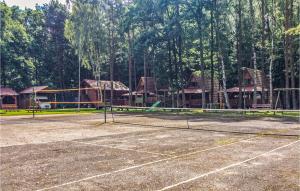 una pista de tenis con una red frente a las casas en Holiday Home Lukecin Ulsloneczna, en Łukęcin 7 fotos más