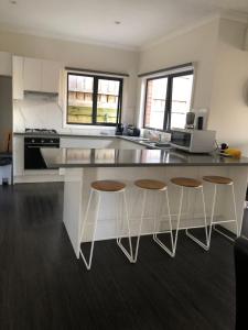 a kitchen with a counter and four stools at Reservoir Paradise in Melbourne