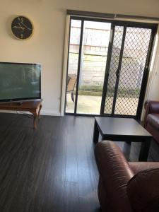 sala de estar con sofá y reloj en la pared en Reservoir Paradise, en Melbourne