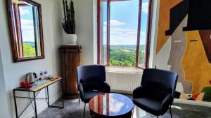 Pokój z 2 krzesłami, stołem i oknem w obiekcie Les Hauts de Domme - Chambres d'hôtes w mieście Domme