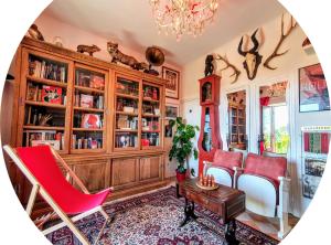 salon z czerwonymi krzesłami i żyrandolem w obiekcie Les Hauts de Domme - Chambres d'hôtes w mieście Domme