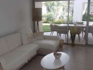 a living room with a white couch and a table at Palmmar Jardines NEW 2bedroom ISORA 0,4 Appt 105m2 with garden in Palm-mar