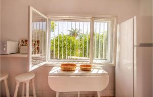 eine Küche mit einem Fenster und einem Tisch mit Körben darauf in der Unterkunft Cozy Home In El Campello With Kitchen in El Campello