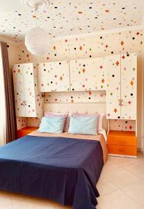 een slaapkamer met een bed en een muur bedekt met confetti bij Family Tree - quiet area -SELF check in in Golem