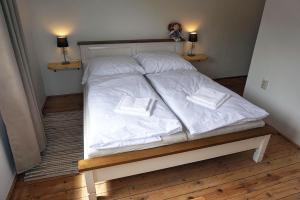 a bed with white sheets and pillows on it at Slnečný dom in Liptovské Revúce