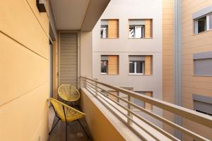 einen Balkon mit 2 Stühlen und ein Gebäude in der Unterkunft Casa Parboni in Rom