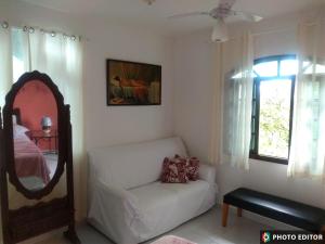 Hostel Vista do Mar في ريو دي جانيرو: غرفة معيشة مع أريكة بيضاء ومرآة
