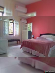 een slaapkamer met een bed met een rode muur bij Hostel Vista do Mar in Rio de Janeiro