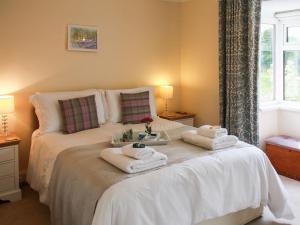 - une chambre avec un lit et des serviettes dans l'établissement The Seaside Cottage, à Gorleston-on-Sea