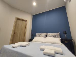 ein blaues Schlafzimmer mit einem Bett, auf dem zwei Handtücher liegen in der Unterkunft Casa Patou in Ponte + 2 Fotos