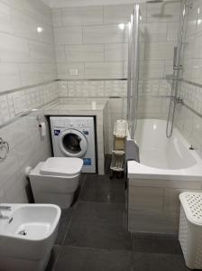 y baño con lavamanos y lavadora. en Casa dei Faggi, en Tolfa