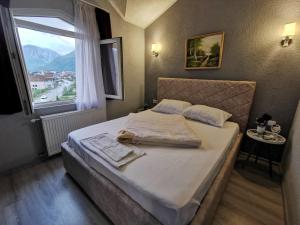 a bedroom with a large bed with a window at Hotel Rosi in Gusinje