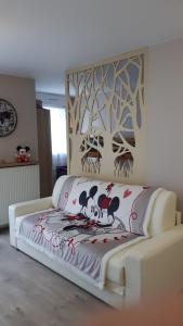 um sofá branco num quarto com um mural de árvore em Le Debussy 5 personnes, lit bébé, balcon, parking privé gratuit em Chessy