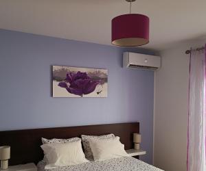 a bedroom with a bed and a purple wall at Casa do Adro - Serra da Estrela in Cortes do Meio