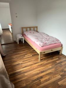 a bed in a room with a wooden floor at Ferienwohnung C&C in Trofaiach