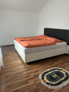 a bed in a room with a rug on a wooden floor at Ferienwohnung C&C in Trofaiach