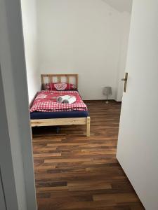 a bedroom with a bed and a wooden floor at Ferienwohnung C&C in Trofaiach