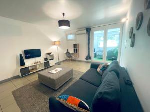 un soggiorno con divano blu e TV di L'Abri-Côtier à 150m de la plage de Boucan a Saint-Gilles-les Bains