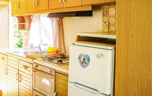 a kitchen with a stove and a white refrigerator at Lovely stacaravan In Darlowo With Kitchen in Darłowo