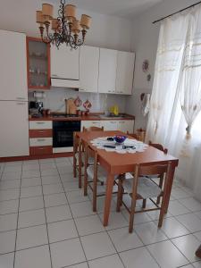 uma cozinha com uma mesa de madeira com cadeiras e um estofados de esteira em Casa Fiorita em Rosignano Solvay