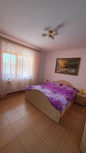 a bedroom with a bed with purple sheets and a ceiling at Casa Caraua in Greci