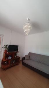 sala de estar con sofá y lámpara de araña en Casa Caraua en Greci