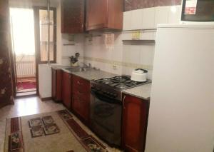 a kitchen with a stove and a refrigerator at Иляева 66 парк Кен Баба in Shymkent