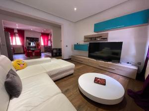 a living room with a white couch and a flat screen tv at Residenza MaryLou in Porto SantʼElpidio
