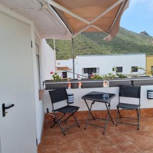 een patio met stoelen en een tafel op een dak bij Santiago del Teide Room in Santiago del Teide