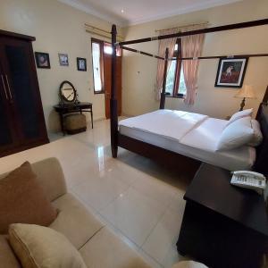 a bedroom with a large bed and a couch at Villa D3 Bukit Cijulang in Bogor