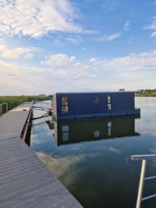 una casa en un muelle sobre un cuerpo de agua en Hausboot auf dem Wangermeer, en Wangerland