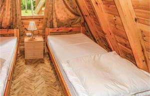 a bedroom with two beds in a log cabin at Gorgeous Apartment In Lukecin With Kitchen in Łukęcin