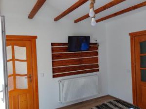 salon z telewizorem na ścianie w obiekcie Wild-Traditional Bucovina w mieście Kimpulung Mołdawski