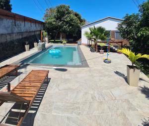 a swimming pool with a bench in a backyard at Villa Mahavel in Saint-Pierre