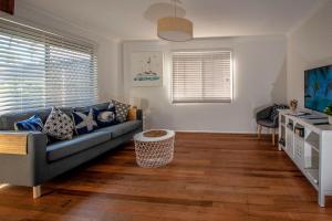 - un salon avec un canapé et une télévision dans l'établissement Holiday House, à Brisbane