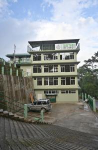 um edifício com um carro estacionado em frente em TreeTops Residency em Shillong