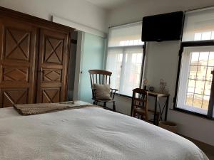 1 dormitorio con 1 cama, 2 sillas y TV en B&B My Suite Home, en Brujas