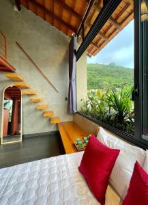 une chambre avec un lit avec des oreillers rouges et un escalier dans l'établissement Soc House 2, à Vung Tau 43 autres photos
