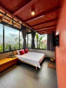 - une chambre avec un lit doté d'oreillers rouges et de fenêtres dans l'établissement Soc House 2, à Vung Tau
