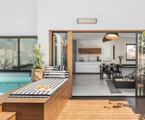 ein offenes Wohnzimmer und eine Küche mit einem Pool in der Unterkunft Mr. Louis - By TLV2GO in Tel Aviv