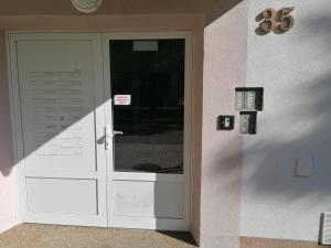 białe drzwi w budynku z napisem w obiekcie Apartmán RUŽA14 w Rużomberku