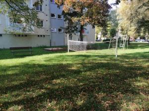 um parque com uma rede em frente a um edifício em Apartmán RUŽA14 em Ružomberok