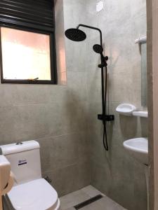 een badkamer met een douche, een toilet en een wastafel bij Rebero View Apartments in Kigali