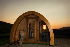 an arched doorway to a small house with the sunset at Kilbane Glamping in Kilbane