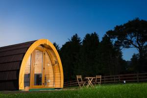 a large wooden barn with a table in a field at Kilbane Glamping in Kilbane
