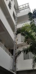 Innsite Room Rentals في مانيلا: مبنى شقق بيضاء مع سلم على جانبها