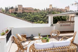 een balkon met stoelen en uitzicht op de stad bij Carmen de Cortes in Granada