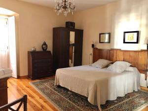 a bedroom with a bed and a chandelier at Apartamento El Parque in Luarca