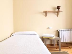 a hospital room with a bed and a shelf at Apartamento El Parque in Luarca