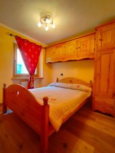 a bedroom with a bed with a red curtain on it at Au Coeur de Saint Nicolas in Saint Nicolas